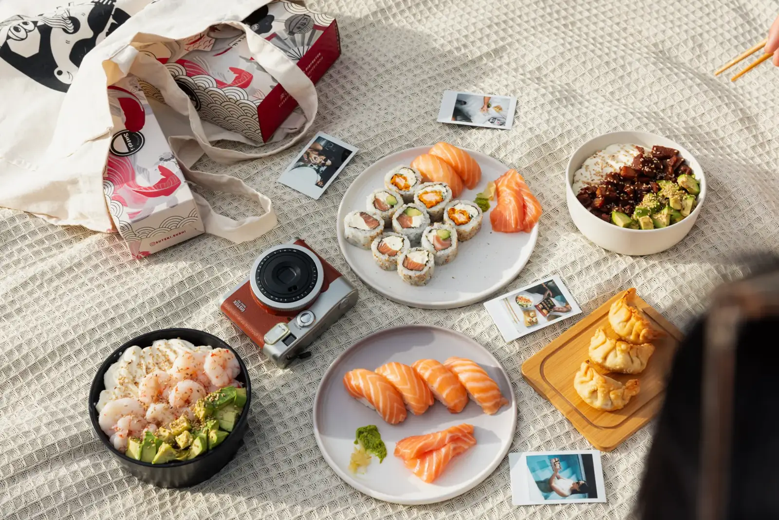 Mesa con sushi, salads y bocados Suteki compartidos al aire libre