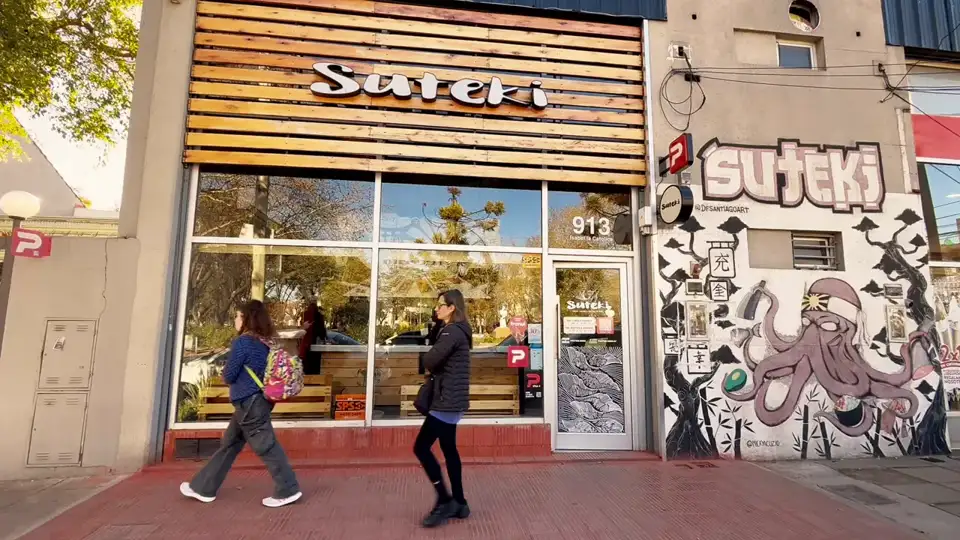 Fachada de Suteki Hurlingham en Isabel la Católica 913: el cartel de madera sobre la vidriera y, al lado de la puerta, el mural del pulpo